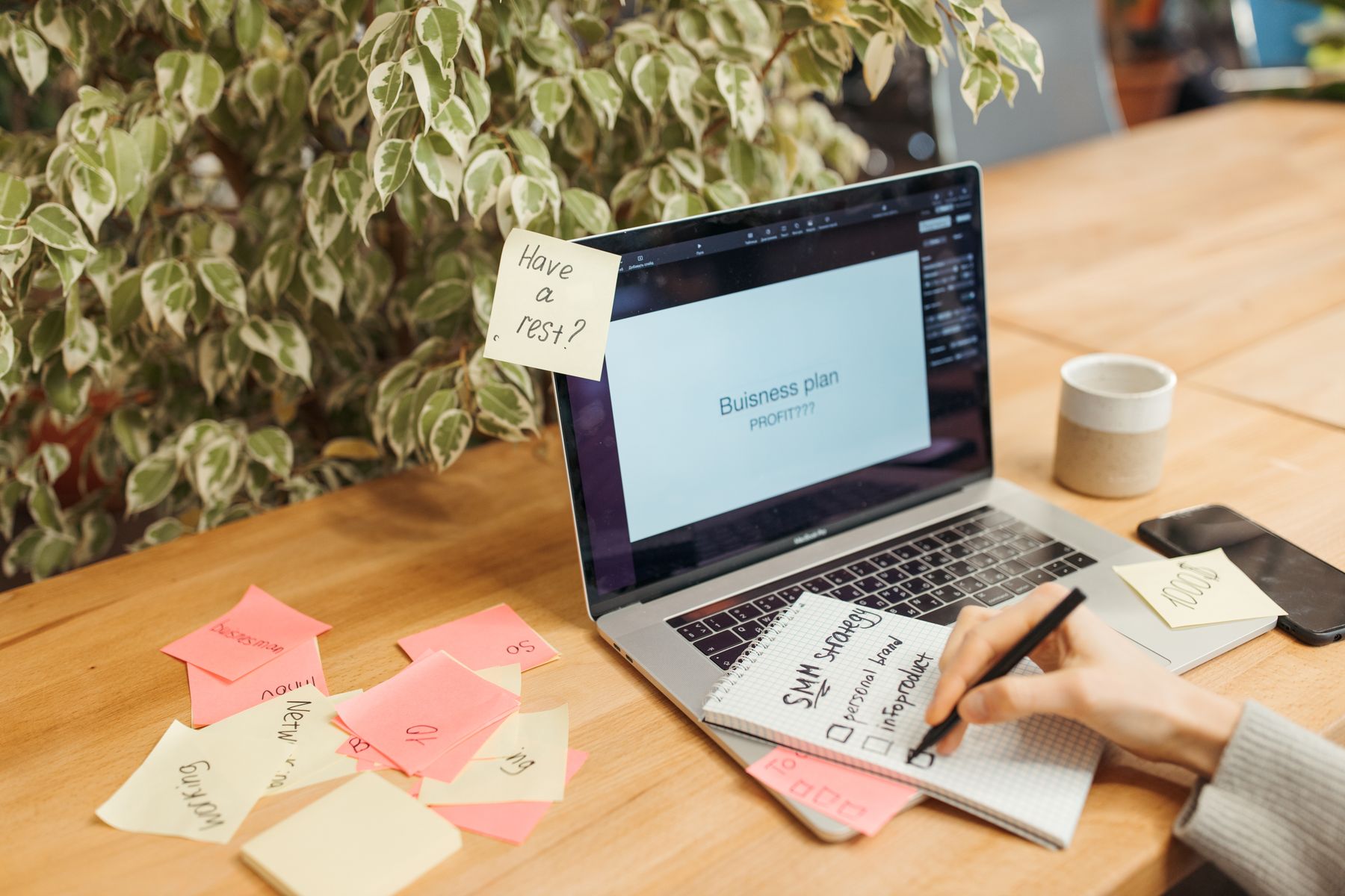Werkplek met een laptop, notities en een kop koffie