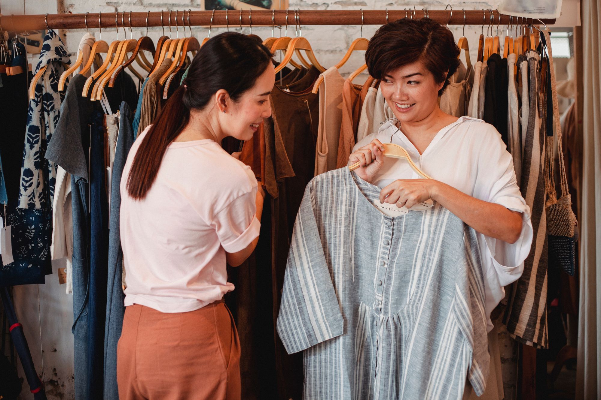 Twee klanten bekijken een jurk in een boutique