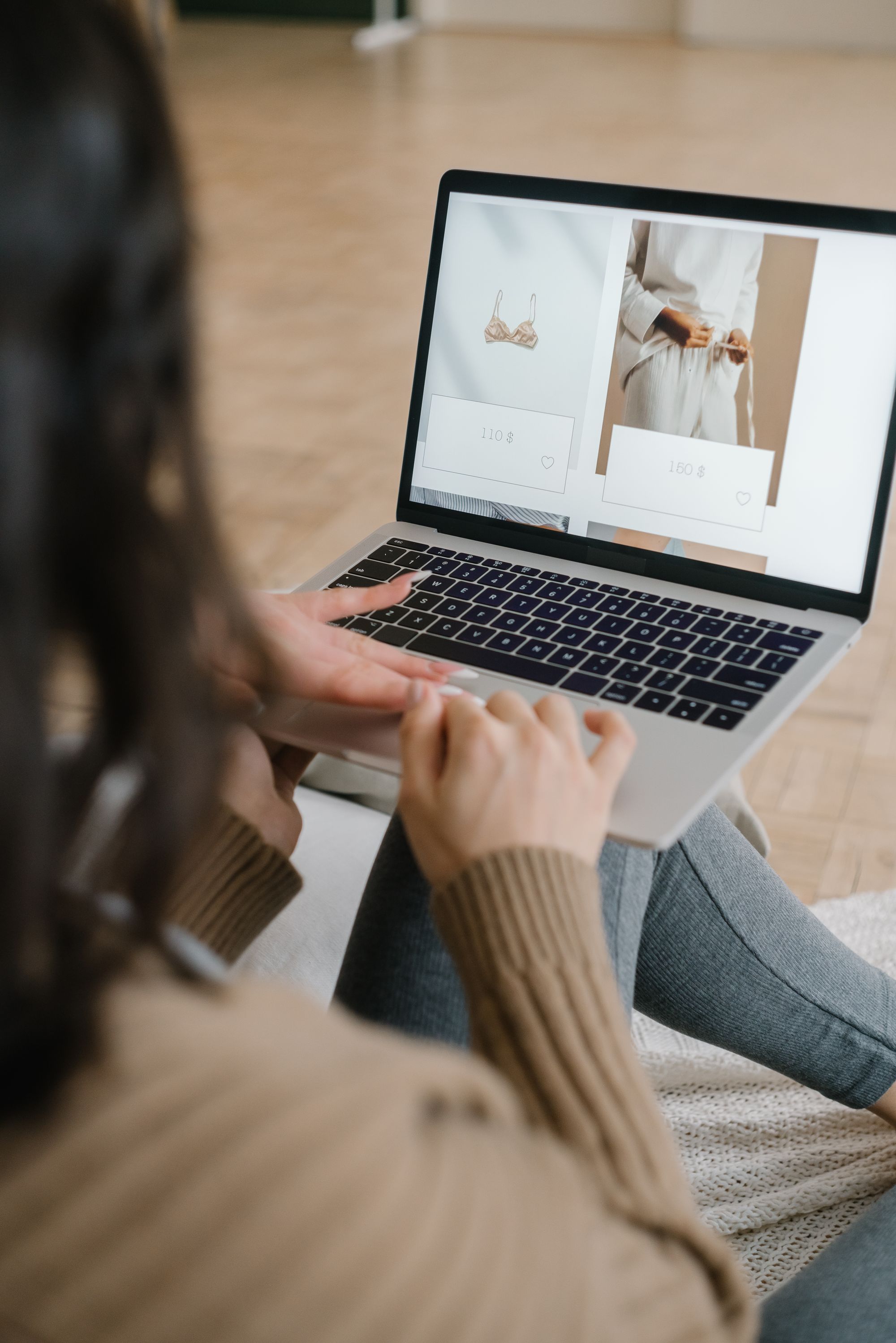 Een klant bekijkt een kledingwebshop op haar laptop