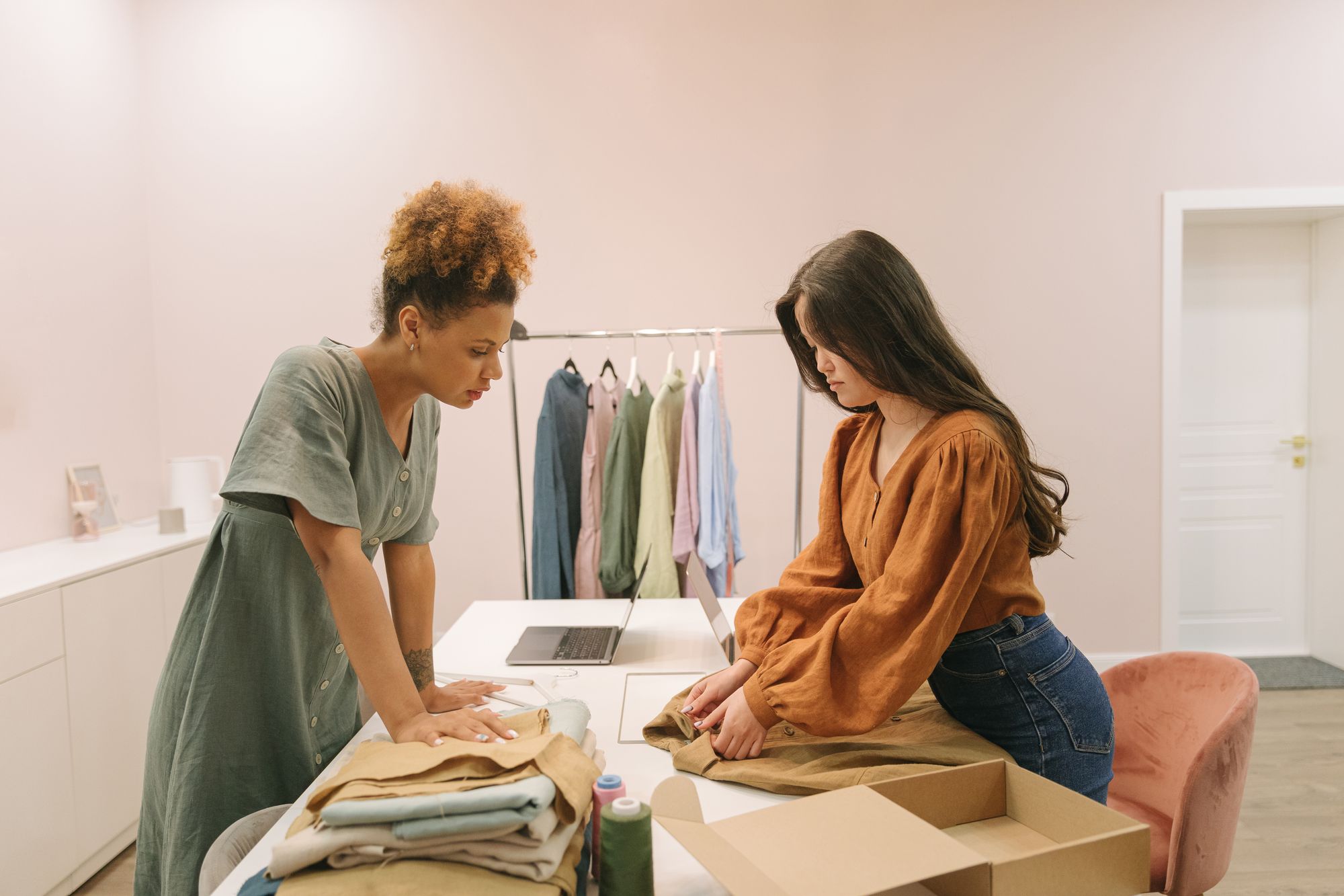 Twee ondernemers vouwen kleding en pakken bestellingen in