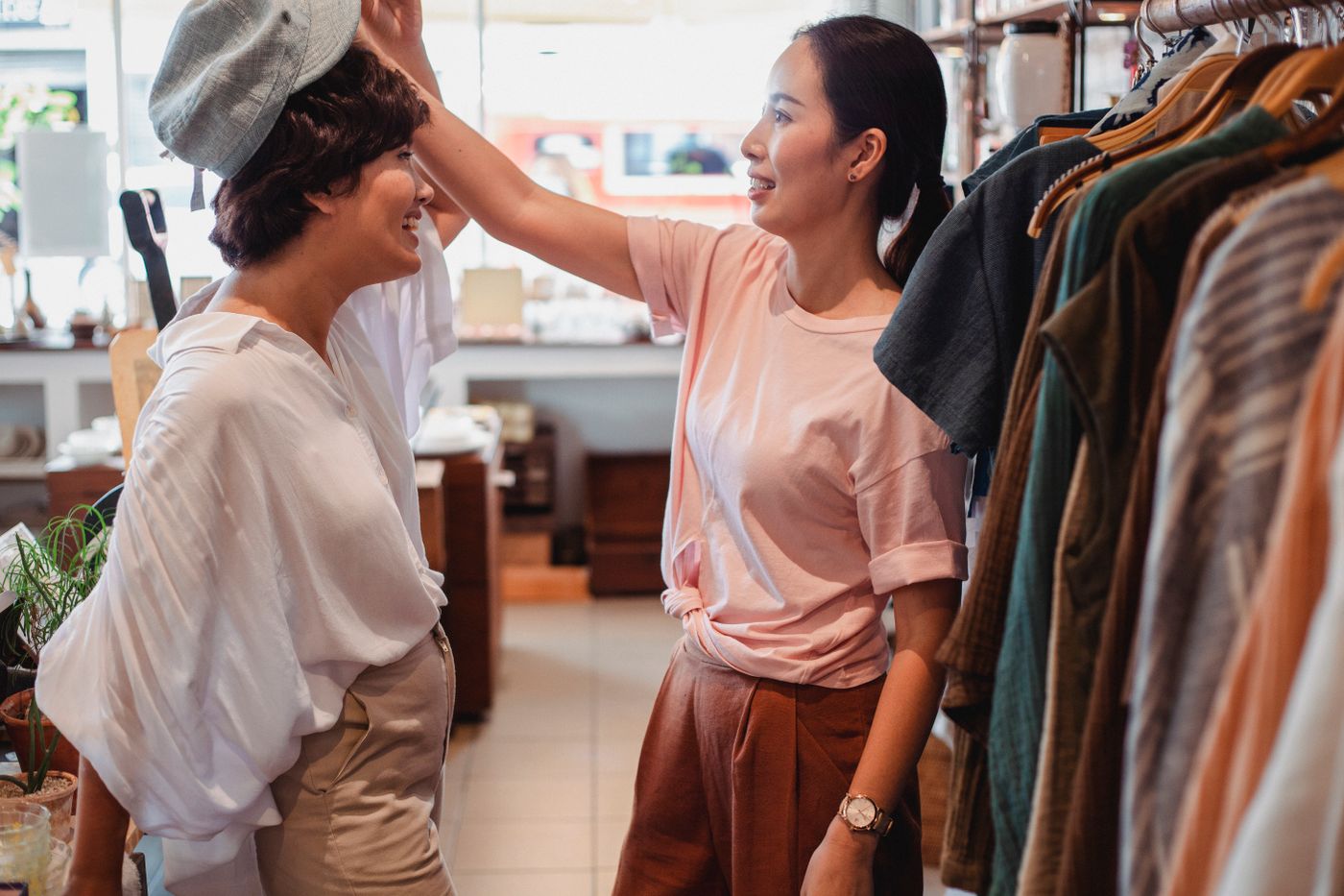 Twee vrouwen bekijken een baret in een boutique