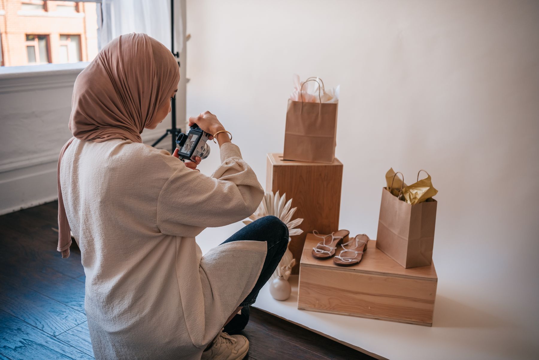 Een ondernemer fotografeert producten bij het raam