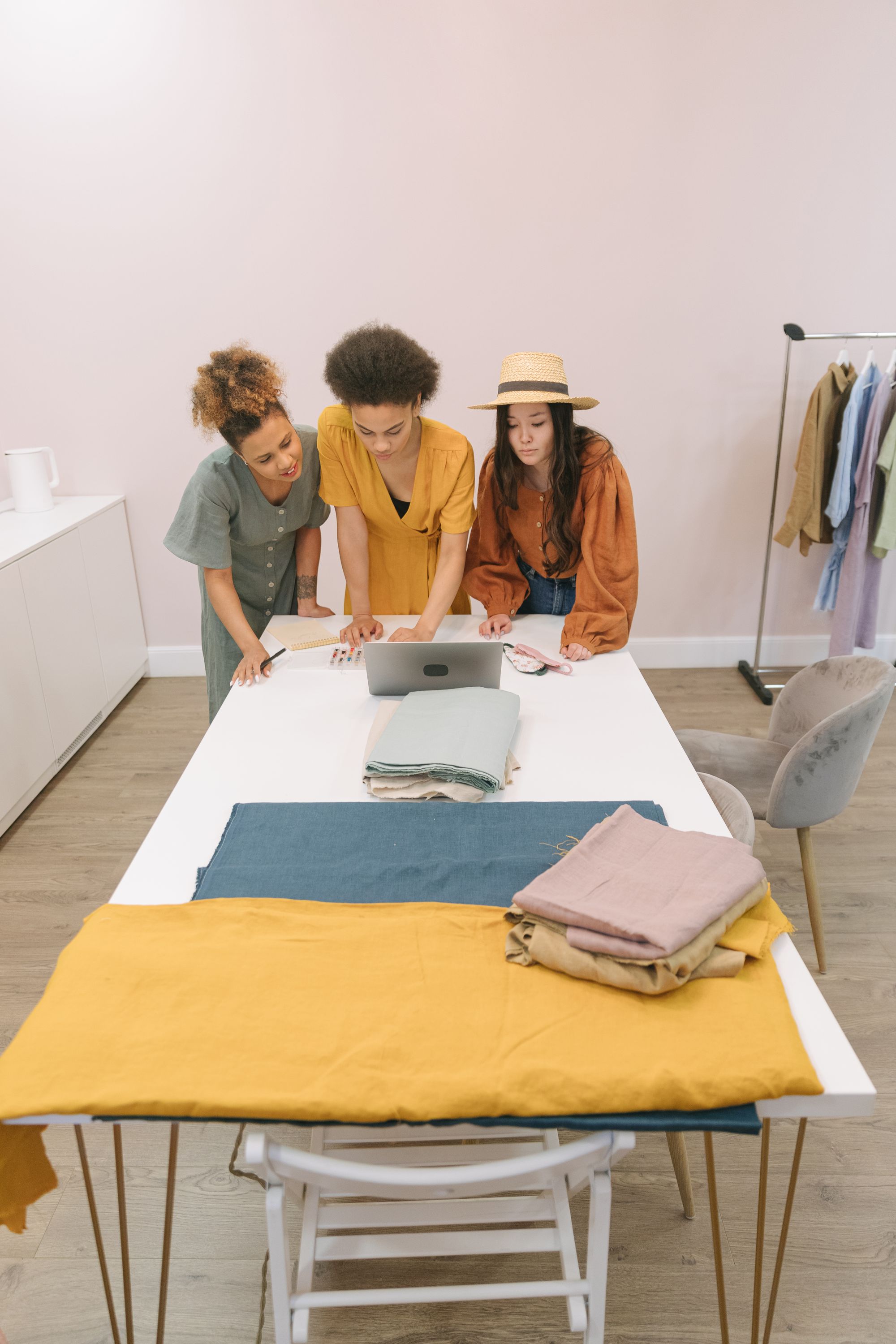 Drie collega’s bekijken hun collectie samen op een laptop