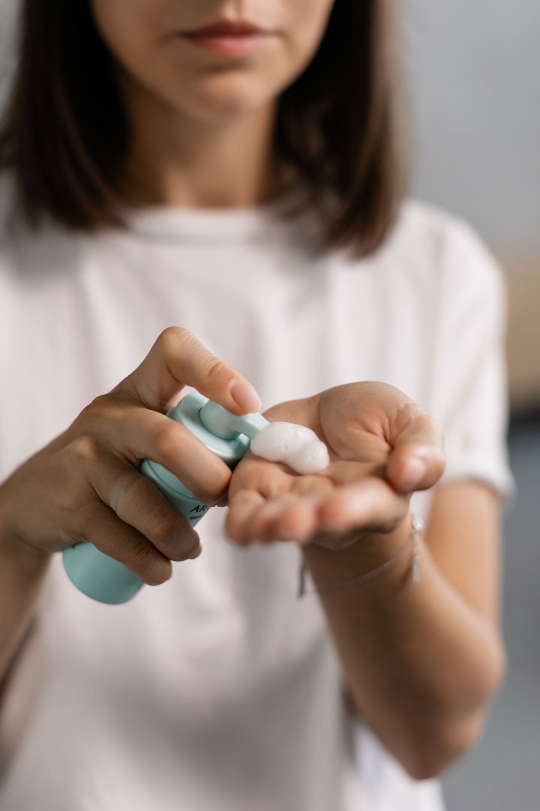 Vrouw brengt verzorgingsproduct op haar hand aan