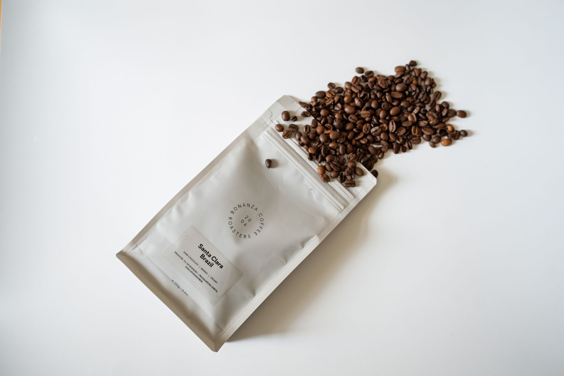 Een witte koffiezak met geroosterde koffiebonen