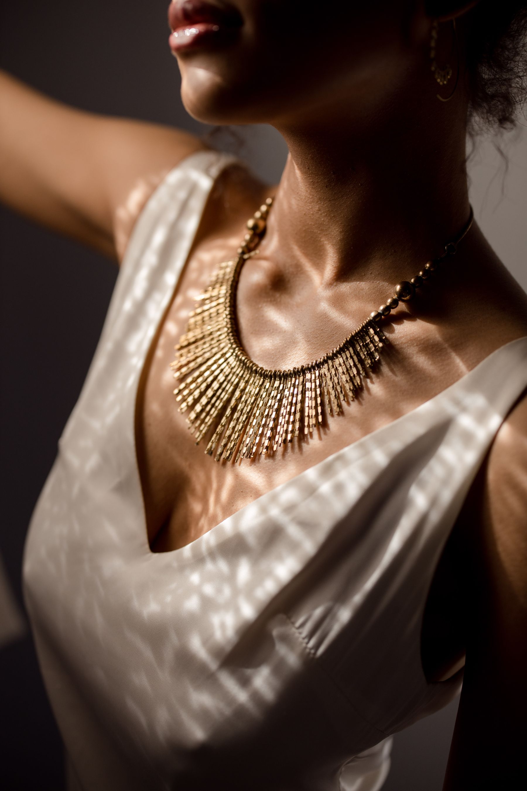 Gouden ketting gedragen bij een lichte blouse
