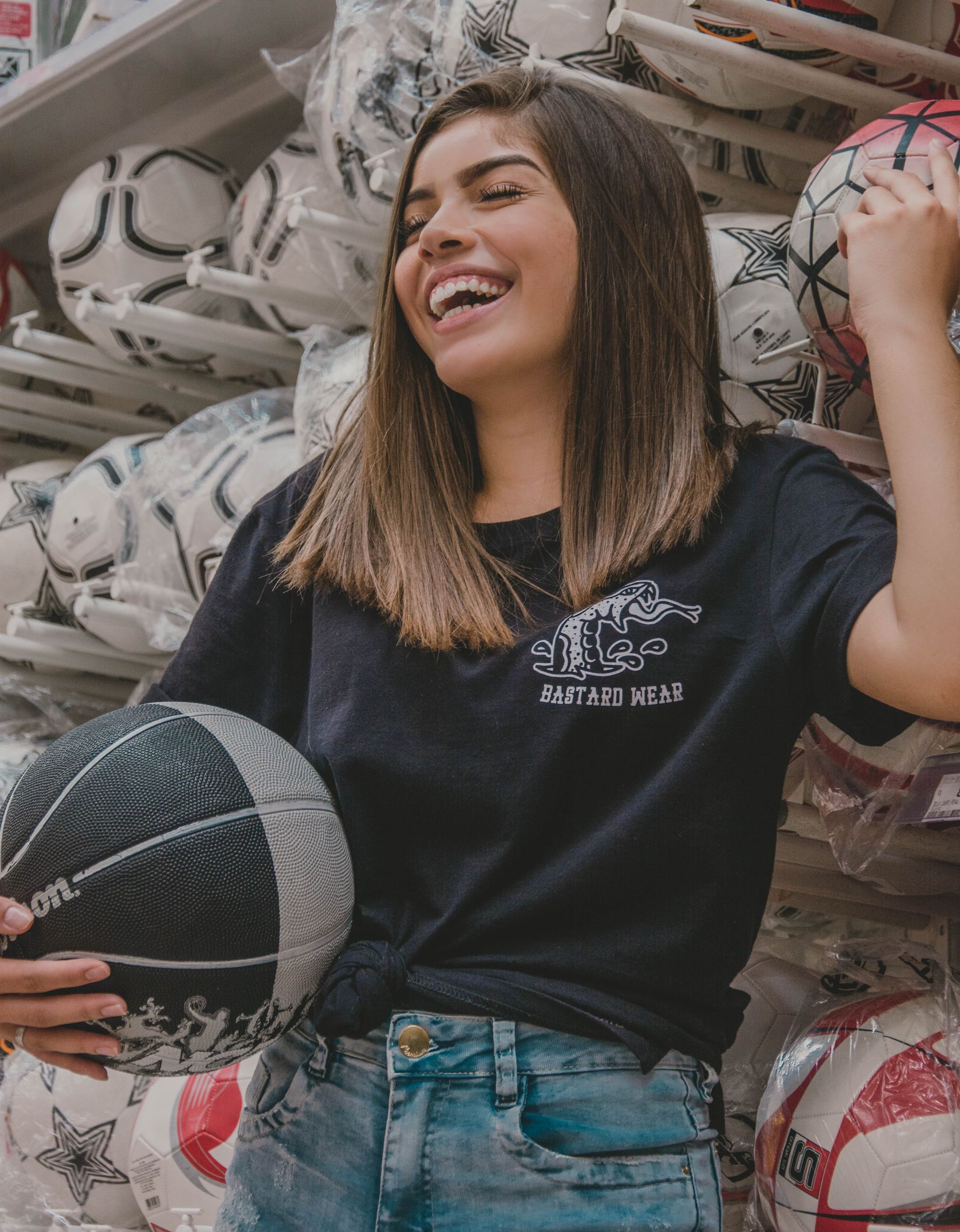 Een vrouw houdt een basketbal vast in een sportwinkel