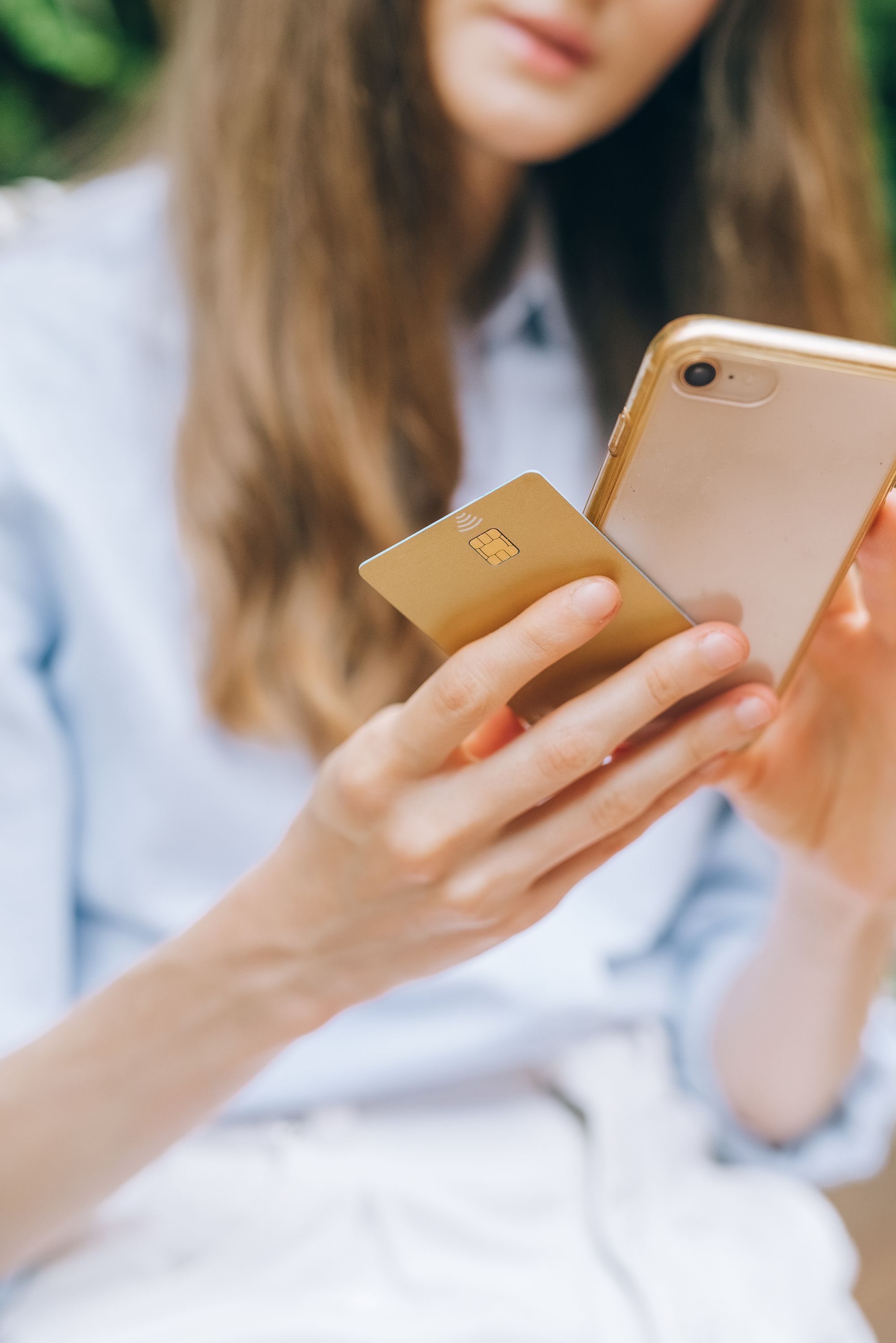 Handen met een telefoon en betaalkaart