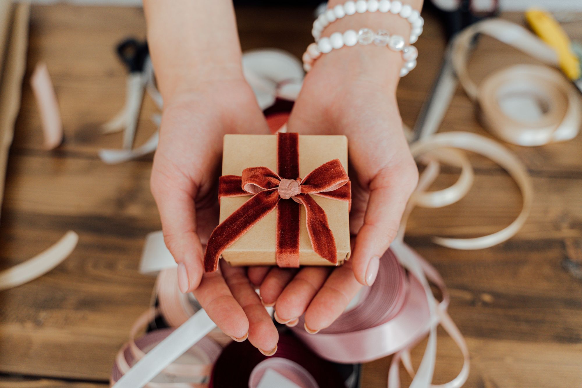 Handen met een klein ingepakt cadeau