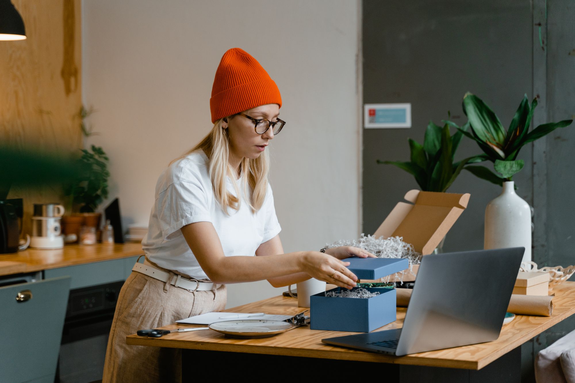 Ondernemer bereidt een productpakket voor aan haar werktafel