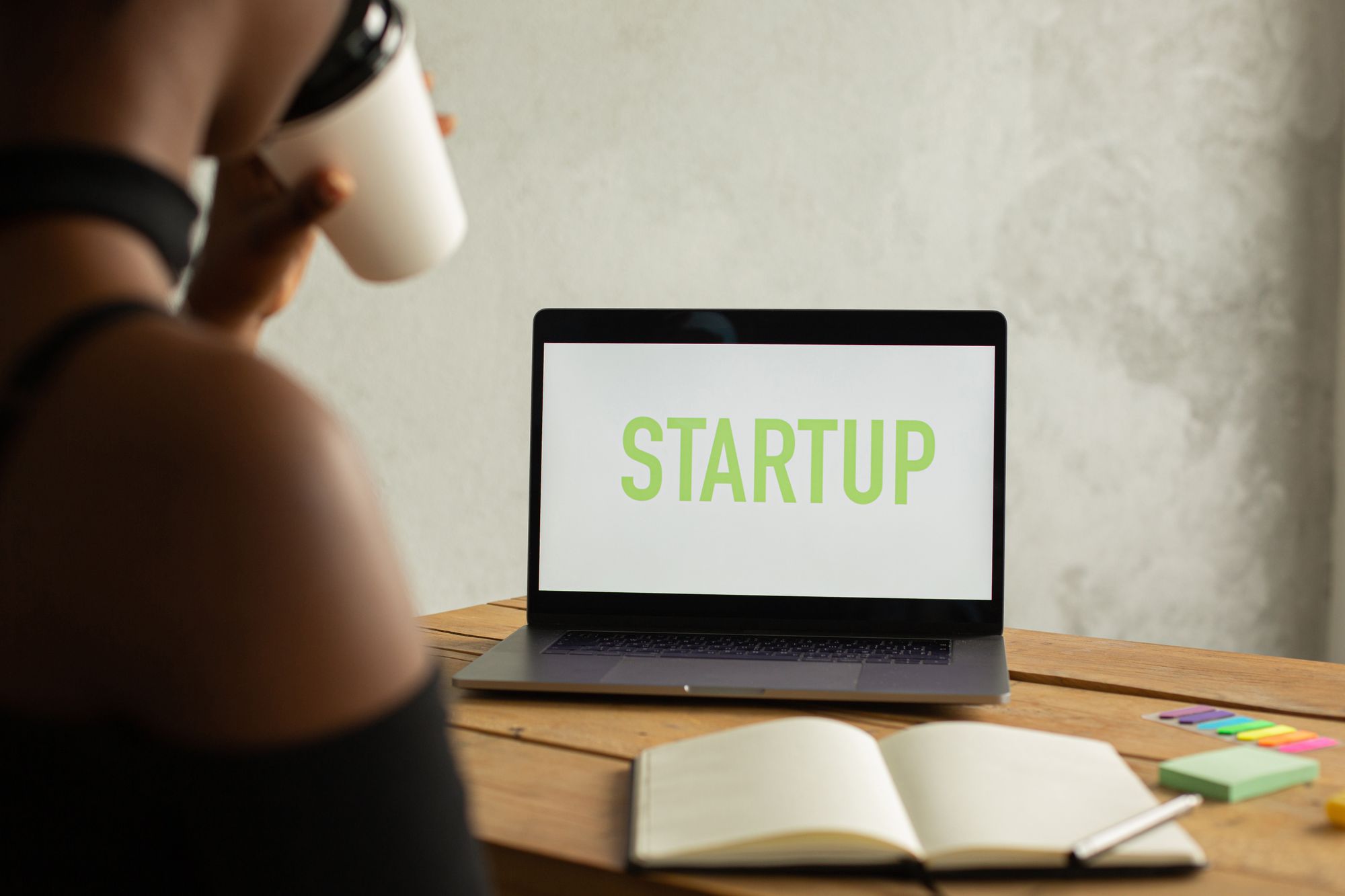 Werkplek met laptop, notitieboek en koffie