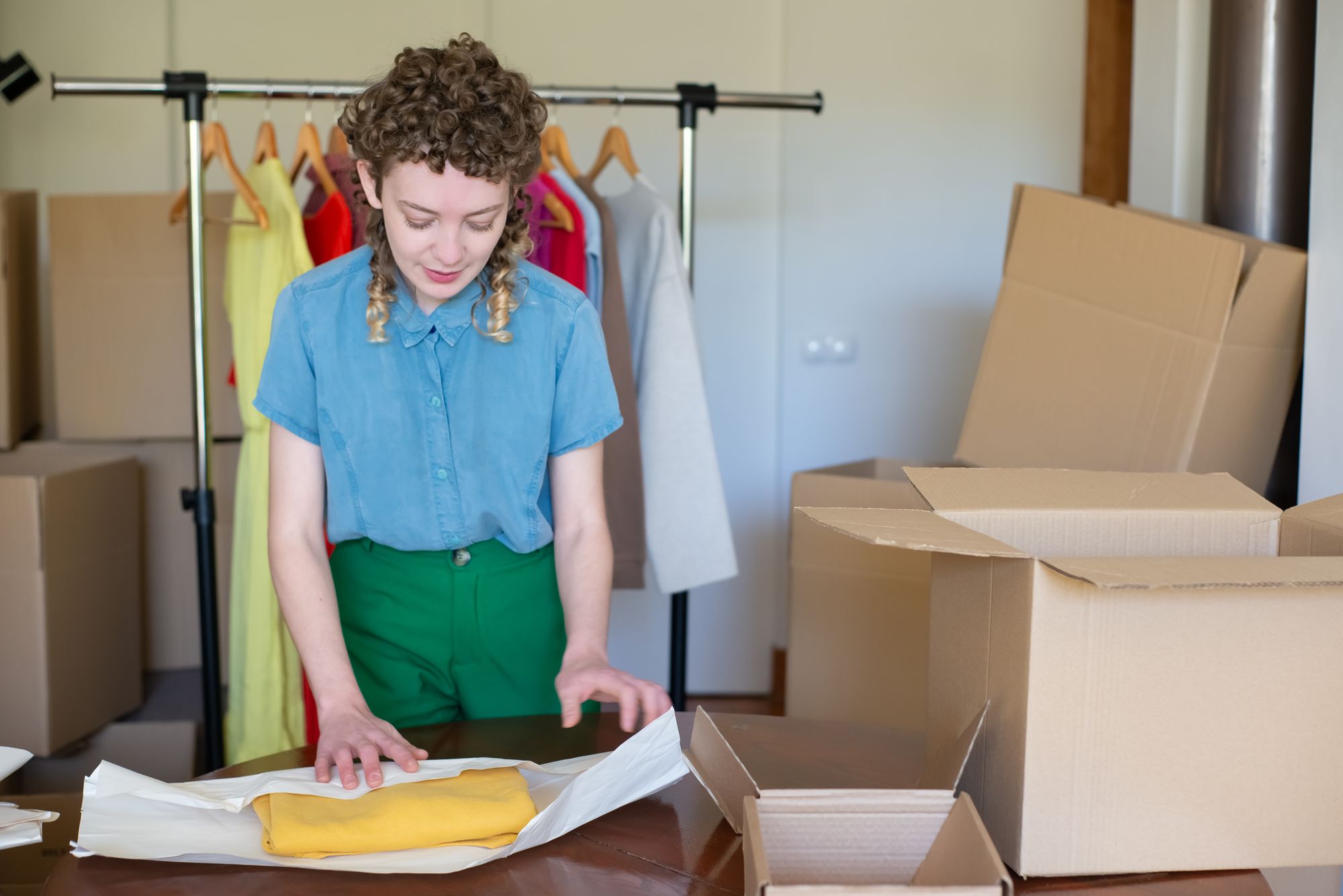 Ondernemer verpakt kleding in een kartonnen doos